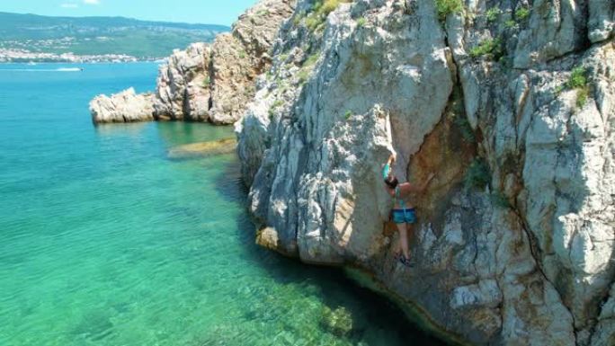空中: 运动女游客深水单人攀爬在碧绿的海面上。