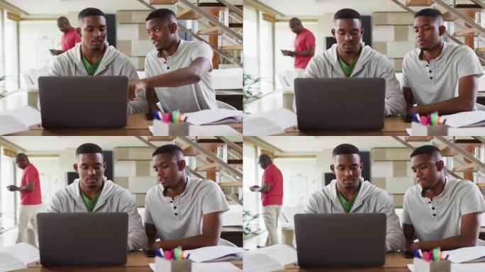 两个非洲裔美国少年双胞胎兄弟使用笔记本电脑并与父亲交谈