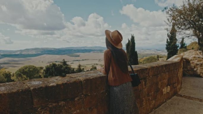 SLO MO女游客在Pienza的城墙上欣赏美景