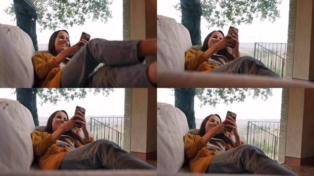 DS年轻女子在使用智能手机时将自己摔倒在沙发上