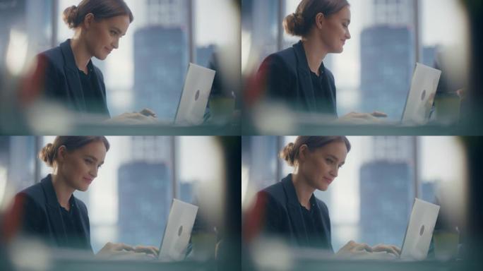 一位成功的女商人在开放式办公室与同事一起在笔记本电脑上工作的特写肖像，自信的女首席执行官分析财务项目