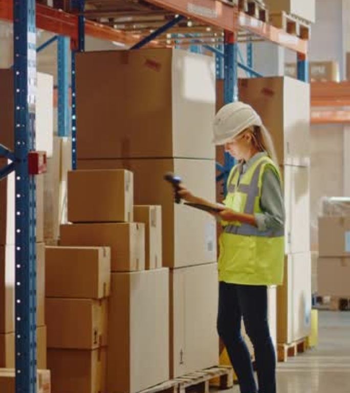 戴着安全帽的专业女工使用数字平板电脑检查库存在装满货架的零售仓库中行走。在物流、配送中心工作。垂直屏