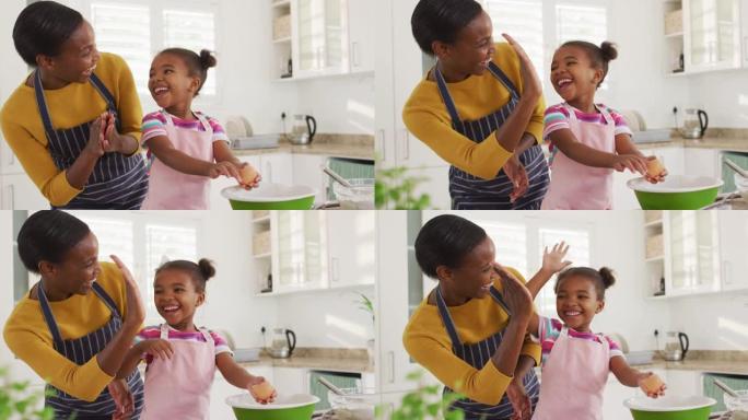 快乐的非洲裔美国母女在厨房做饭和给高五
