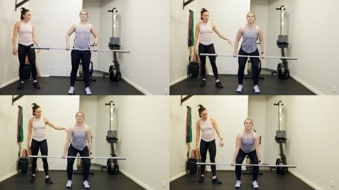 女人在健身房用杠铃和健身教练一起锻炼