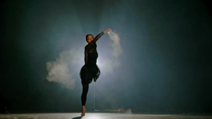 超级SLO MO职业芭蕾舞演员在舞台上旋转时向空气中扔灰尘