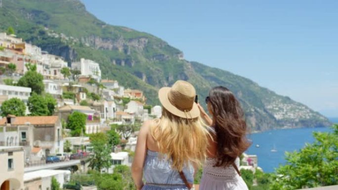 两名度假妇女一起使用智能手机拍摄意大利城市的照片