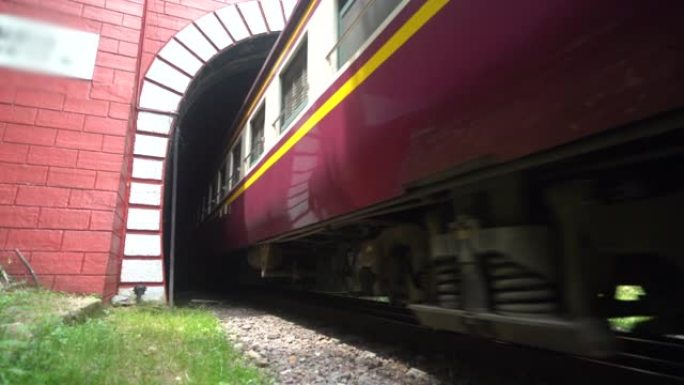 一列铁路柴油火车正在离开隧道。