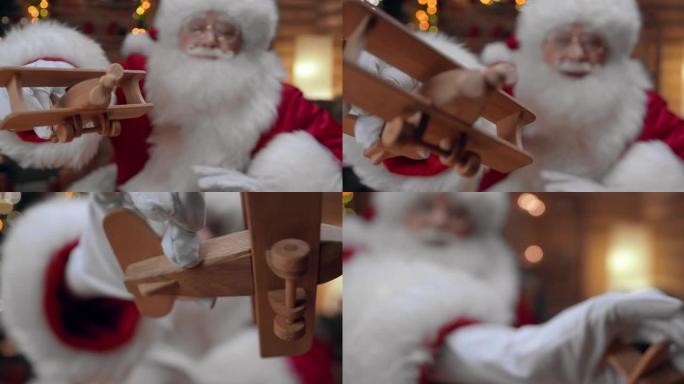 圣诞老人玩可爱的木制飞机，我们看到他在圣诞节的室内，圣诞树在专业的灯光下