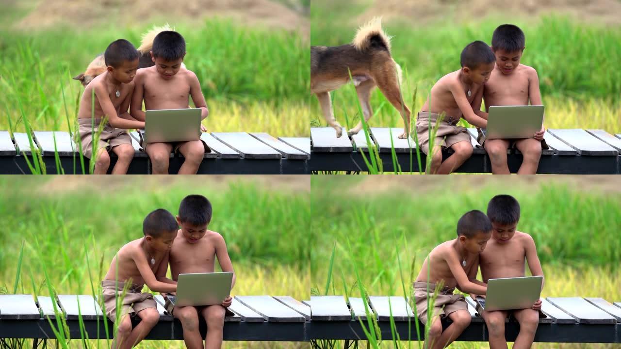 两个农村男孩玩笔记本开心