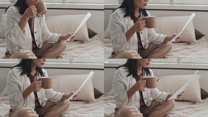 女人阅读文件和喝咖啡