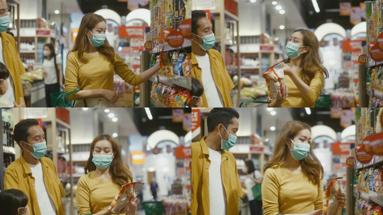 亚洲家庭戴着口罩，在超市买食物。