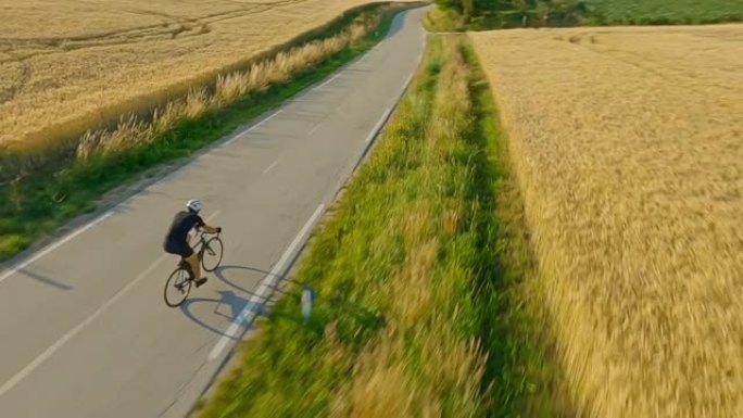 空中运动员骑自行车穿越乡间公路
