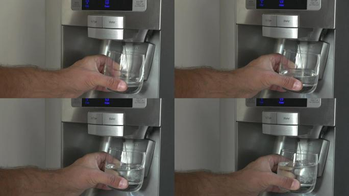男人从冰箱里拿一杯冷水的特写镜头