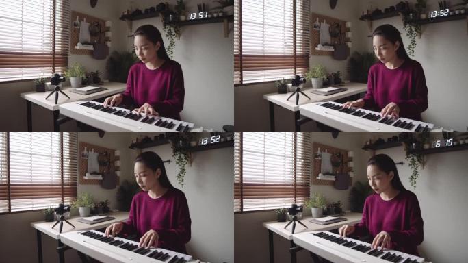 年轻女子在家通过视频教程在互联网上上钢琴课。