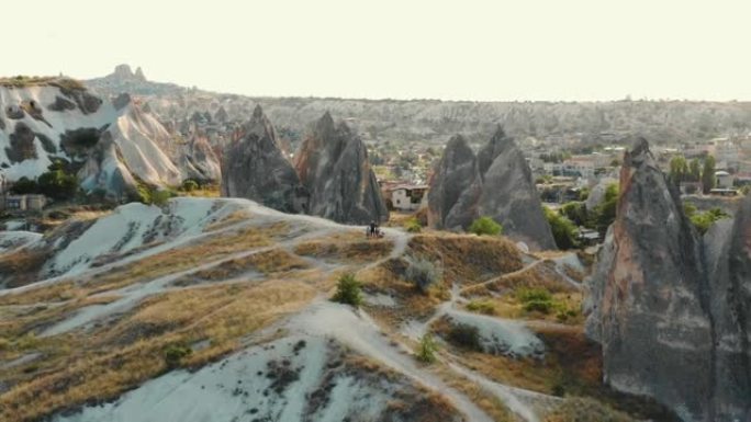 无人机飞越美丽的大气日出岩石全景，带着孩子享受山路旅行的家庭。