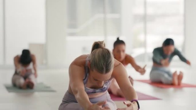 一群健康的女性在健身健身房一起做瑜伽，作为锻炼的一部分。在健身中心锻炼和训练的活跃和运动的女性。运动