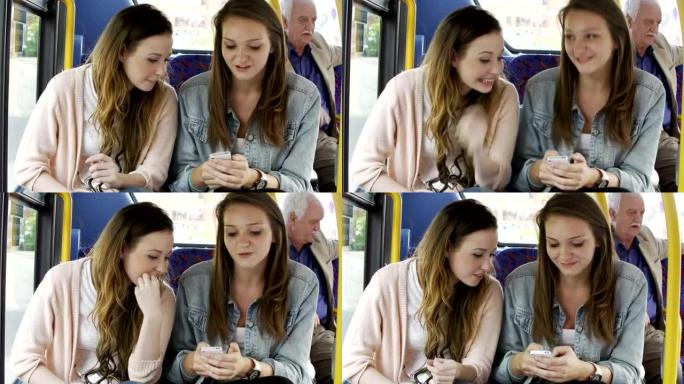 两名年轻妇女在公共汽车上阅读短信