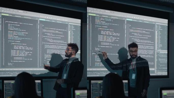 垂直屏幕: 老师在黑暗的大学教室里为不同的多种族学生提供计算机科学讲座。用编程代码投影幻灯片。解释信