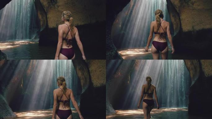 瀑布洞里的美女穿着比基尼独自探索地下洞穴，水溅起光线
