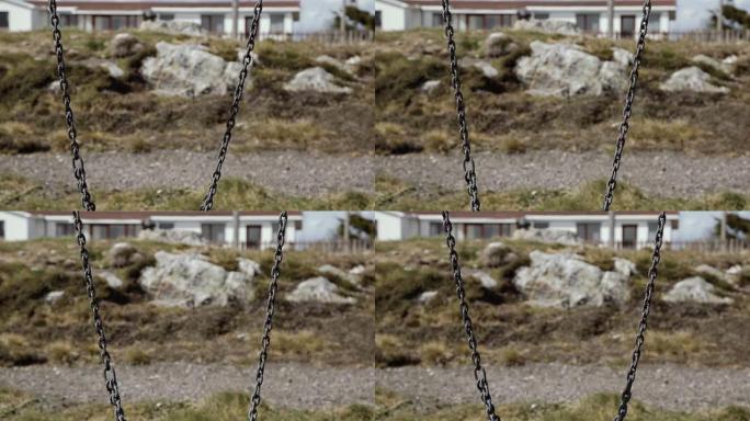 在福克兰群岛 (马尔维纳斯群岛) 斯坦利港的一个公园里，一个空荡荡的生锈链。特写。