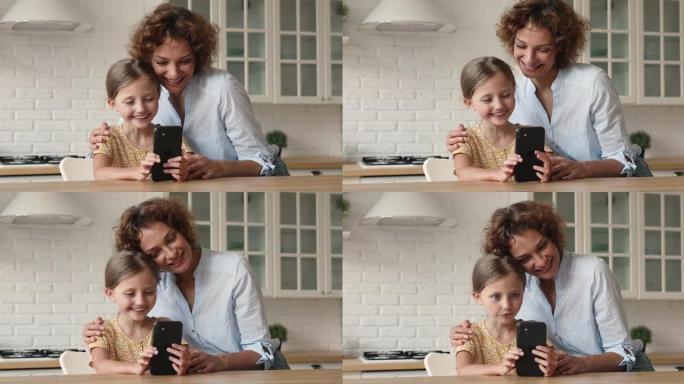 母亲和小女儿使用智能手机玩得开心