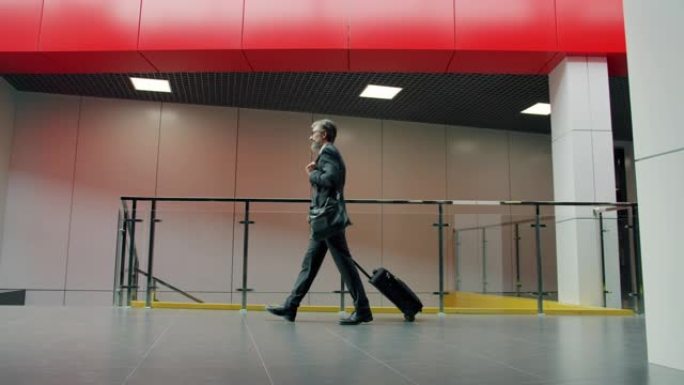 穿着西装的商人带着手提箱去机场参加商务会议