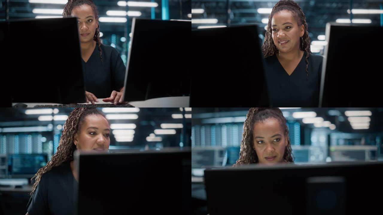 非裔美国女性IT专家在数据中心桌面工作的肖像。系统管理员工作于Web服务、云计算、服务器分析、网络安