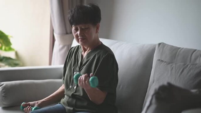 亚洲中国高级女性照顾自己她在家用哑铃锻炼
