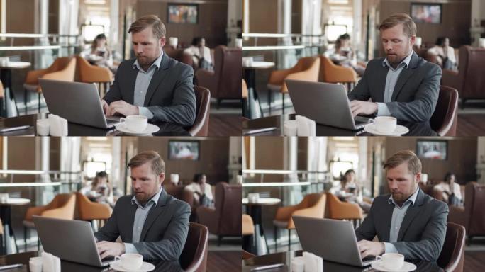 在餐厅使用笔记本电脑的商人