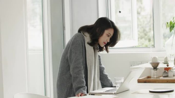漂亮的亚洲女商人忙着用笔记本电脑在家工作