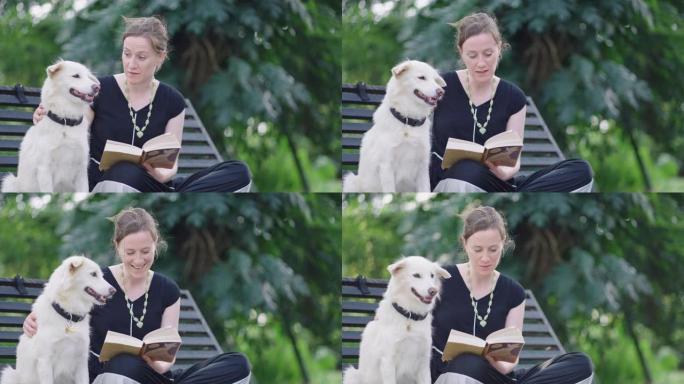 女人在公园里给狗读睡前故事