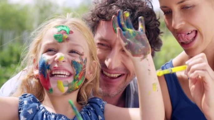 一个小女孩和她的父母在户外一起玩油漆的4k视频片段