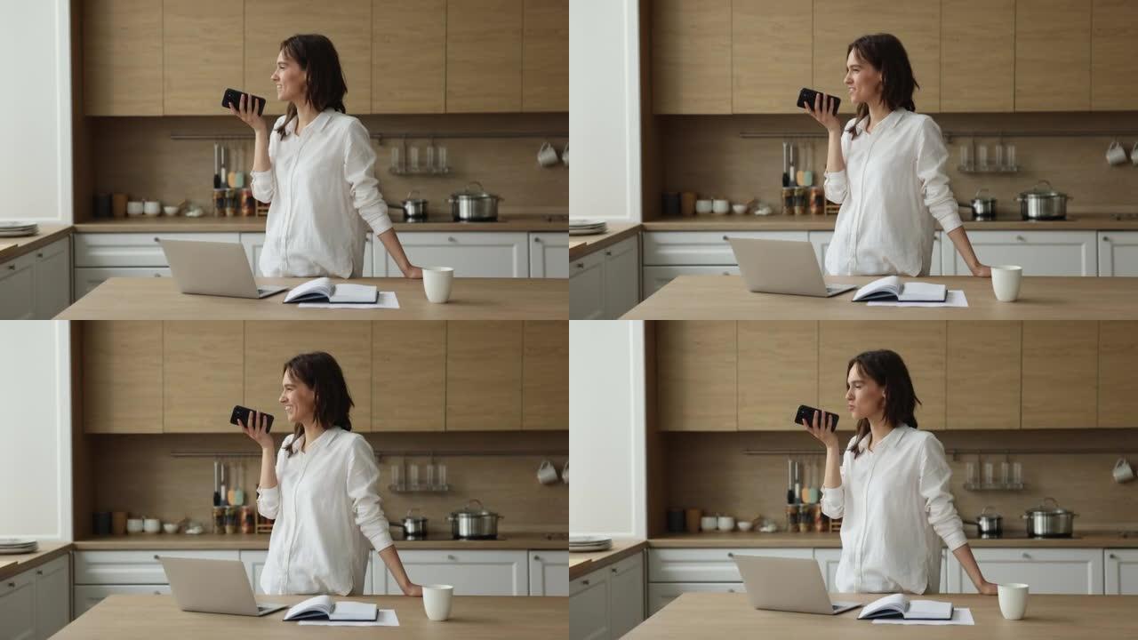 女人站在厨房里用免提电话在手机上交谈