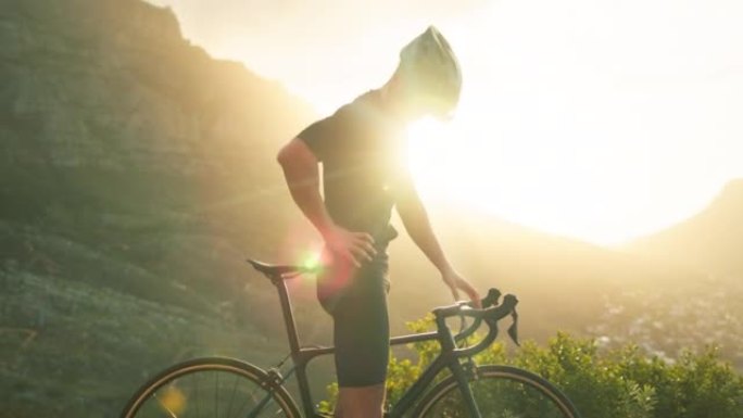 骑自行车的人背痛，肌肉和受伤在自然之旅头盔或安全装备和户外日落镜头耀斑的山地自行车。在山上和自行车上