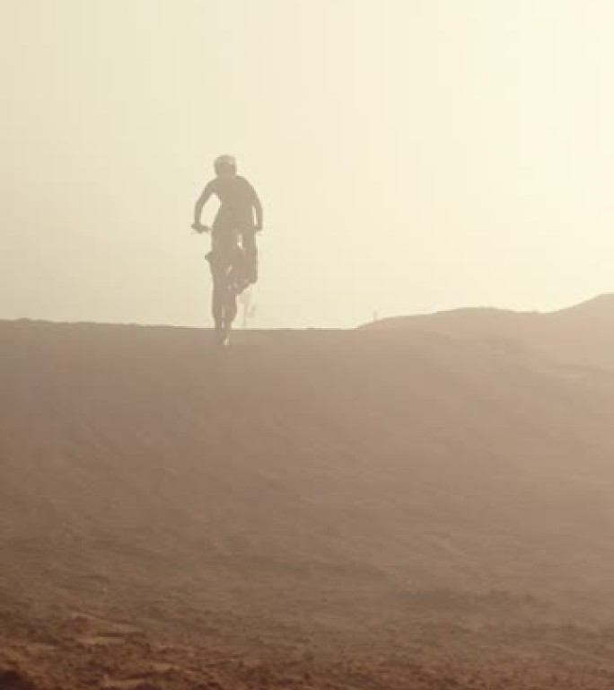 跳跃，运动和男子在越野自行车上在沙漠沙滩上进行冒险或极端特技表演。摩托车越野表演，自由和骑摩托车或摩