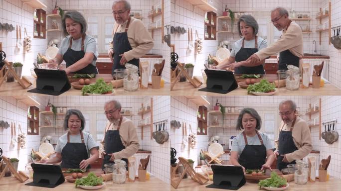 老年夫妇正在学习如何使用平板电脑在厨房中烹饪食物，表达了他们对他们的持久爱。以及退休后的幸福，是通过