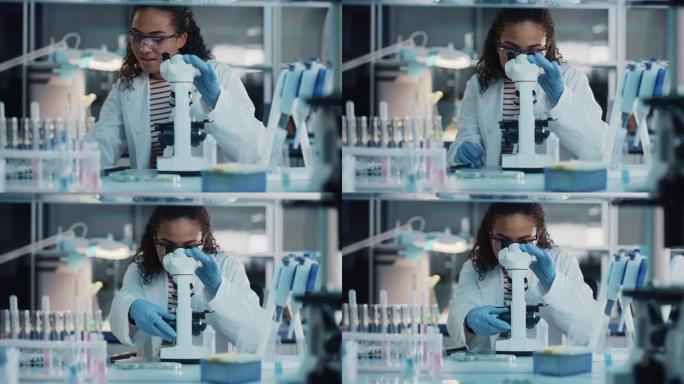 医学科学实验室: 美丽的黑人科学家在显微镜下观察的肖像对测试样品进行分析。雄心勃勃的年轻生物技术专家