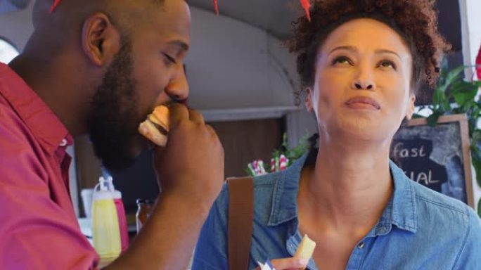 非裔美国人夫妇在食品卡车上一起吃汉堡和薯条的特写