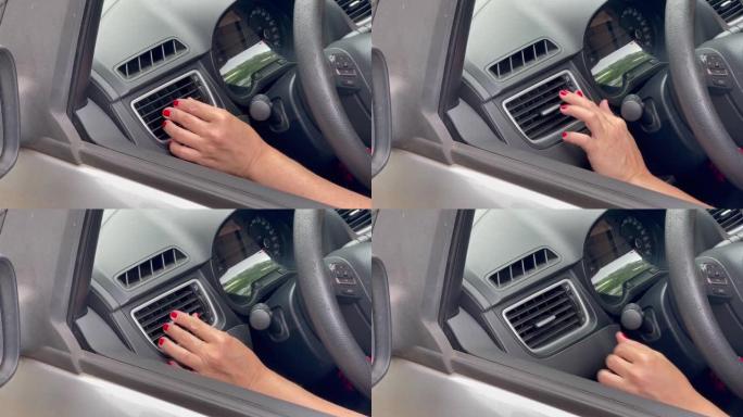 一名司机女士的手转动通风格栅。特写。4k分辨率。