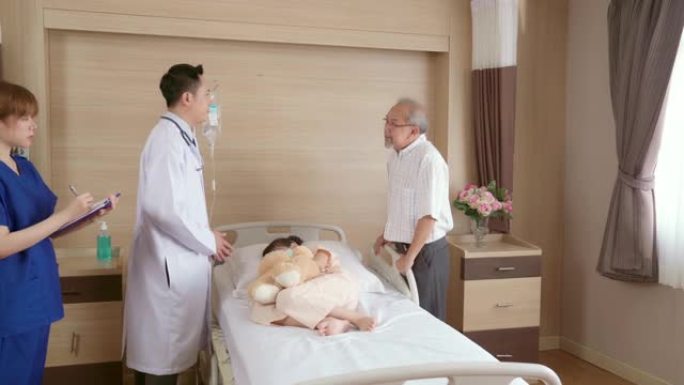 4K UHD Dolly右: 医生在医院病房看望小女孩病人，并向父母解释症状。医院医疗保健概念。