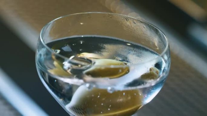 专业调酒师的特写镜头正在酒吧或迪斯科俱乐部为顾客提供精英酒精鸡尾酒。
