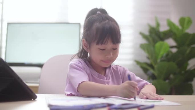 亚洲女儿在家学习数字平板电脑上的在线课程