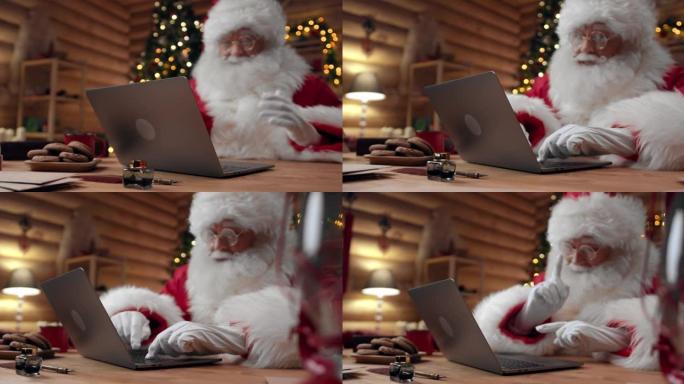圣诞老人正在视频聊天，使用他的笔记本电脑，而相机将他从一侧拍摄到另一侧