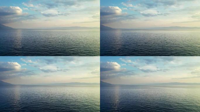 飞越无尽的蓝色湖面。背景上的蓝天和云。北马其顿奥赫里德湖