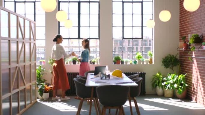 建筑师，工程和创意女性在现代绿色办公空间中交谈，讨论和规划城市建设。设计师、商人和开发团队在项目上合