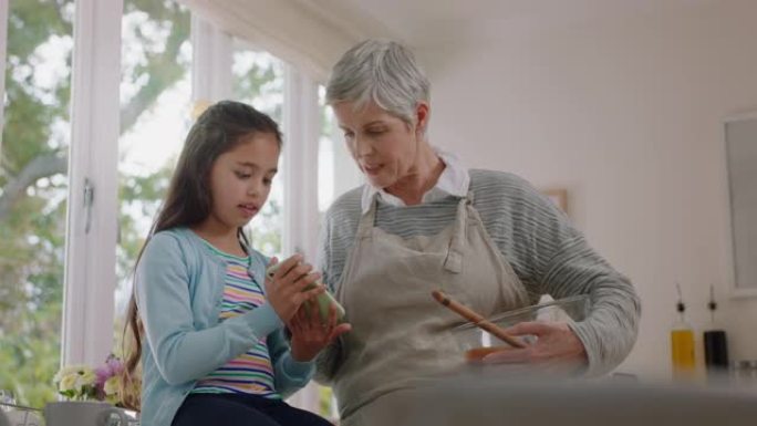 可爱的小女孩展示奶奶如何使用智能手机教学奶奶现代技术智能孩子在家帮奶奶带手机