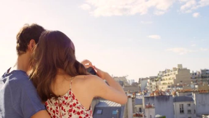 一对年轻夫妇在俯瞰法国巴黎埃菲尔铁塔的公寓阳台上拍照的4k视频片段