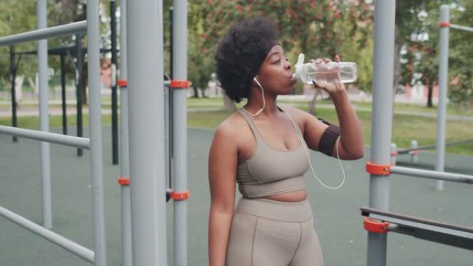 非裔美国妇女在户外锻炼时喝水