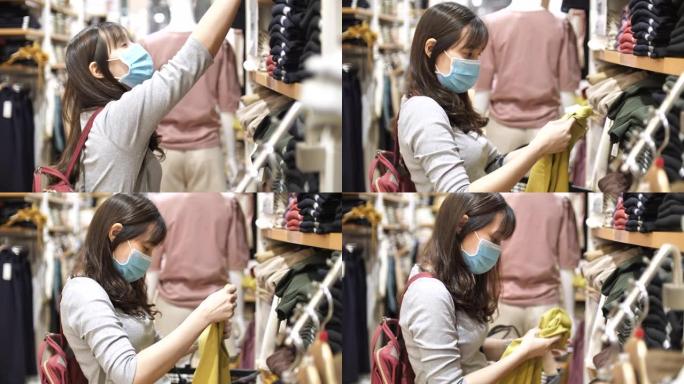 亚洲女子戴口罩在商场购物服装