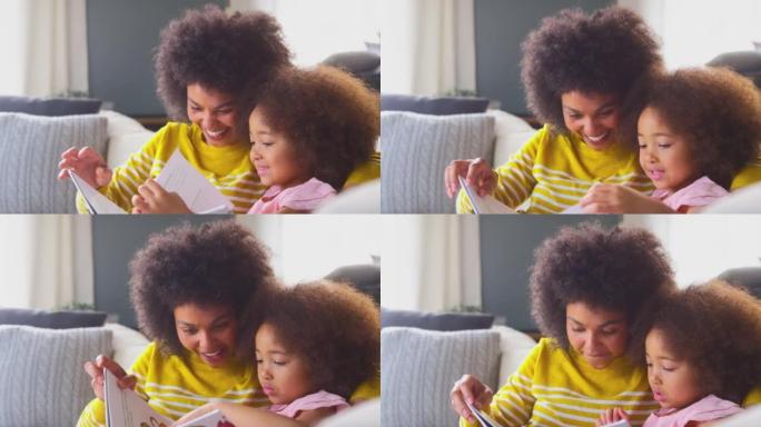 女儿和妈妈一起坐在沙发上看书-慢动作拍摄